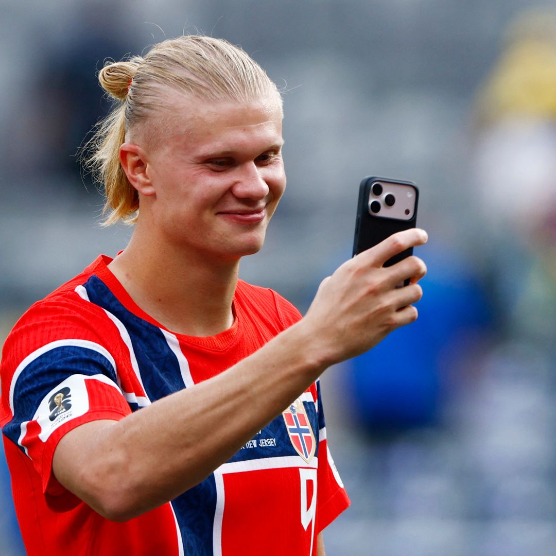 Erling Haaland, de Noruega , sostiene su teléfono en el campo. Foto: Reuters